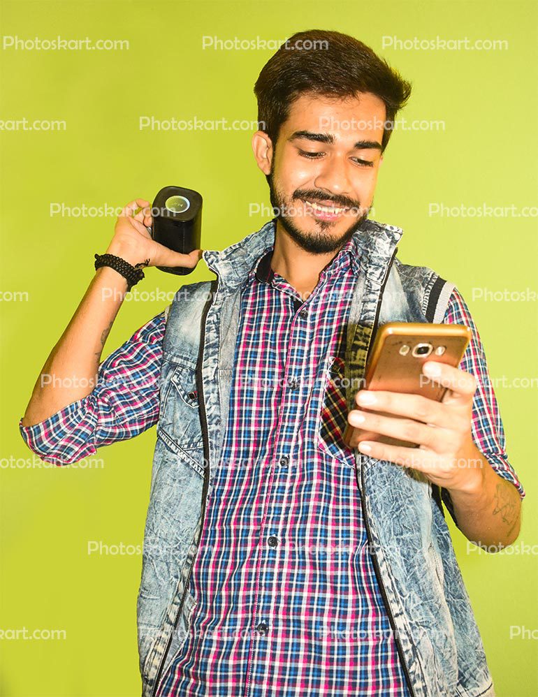 Happy Indian Boy Playing Song Using Bluetooth Speaker