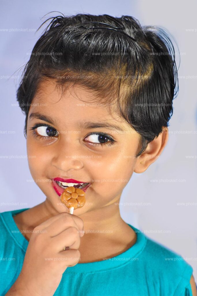 A Little Indian Girl Eating Lollipop