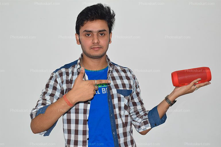 An Indian Boy Showing A Bluetooth Speaker On Hand