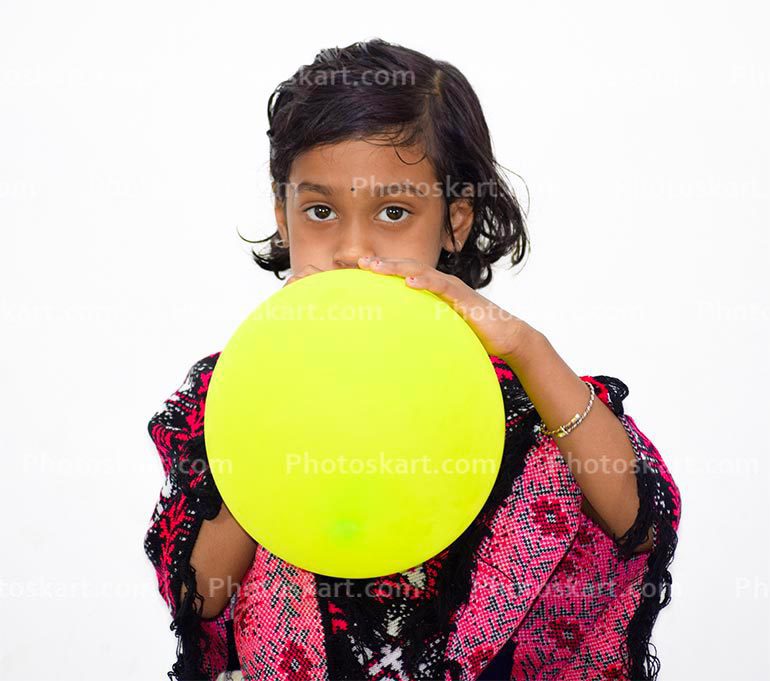 Indian Girl Blowing Up Balloon Indoors