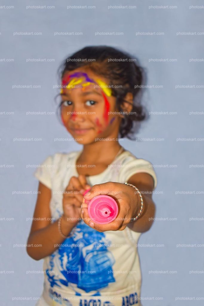 A Little Girl Enjoying Holi Of Colors Holding A Pichkari