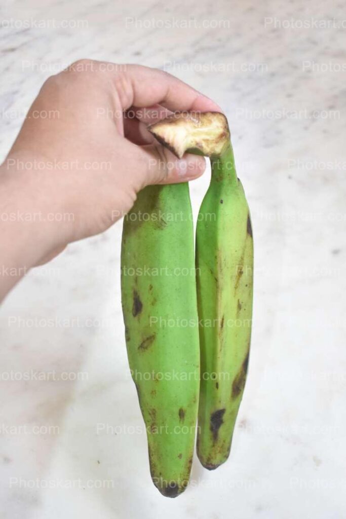 Green Banana Holding By Hand