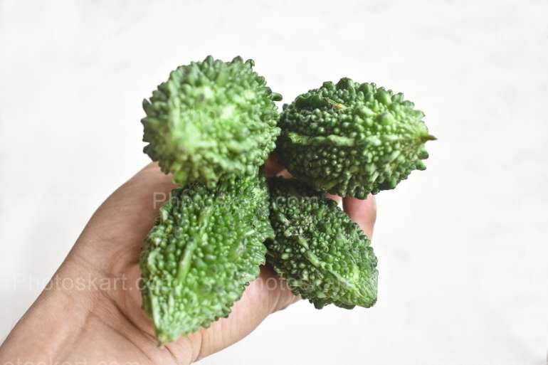Holding Bitter Gourd On Left Hand Stock Photo