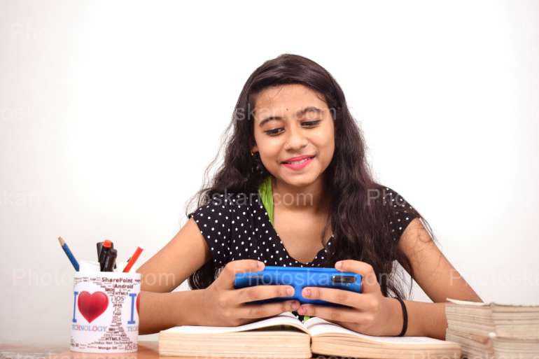 Indian Girl Using Phone At Study Time Stock Image