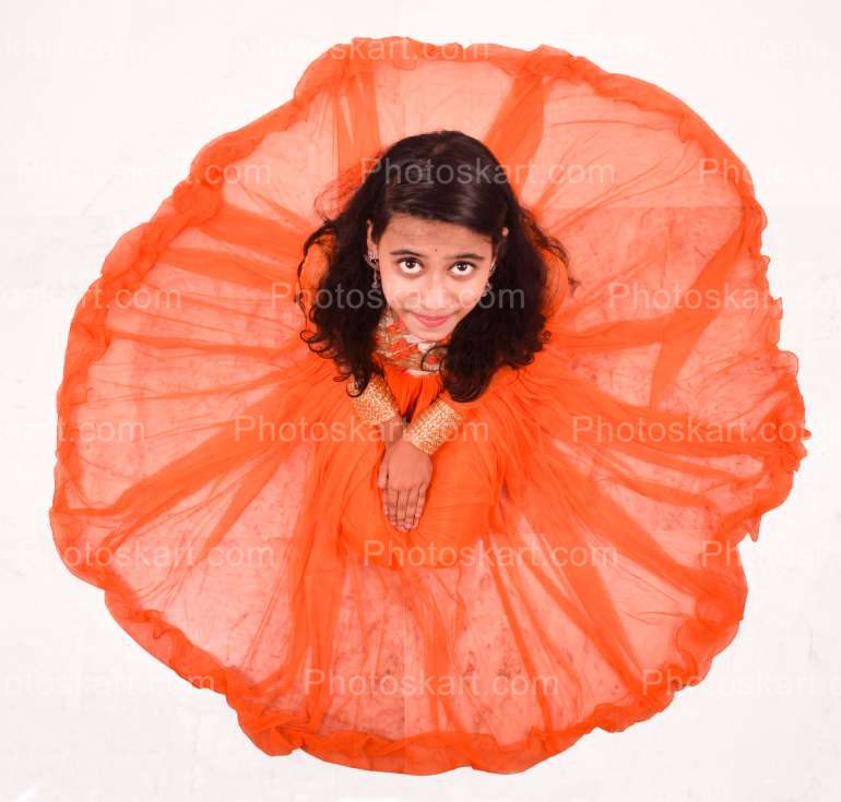 A Woman In Luxurious Orange Dress Sitting In Circle Long Skirt