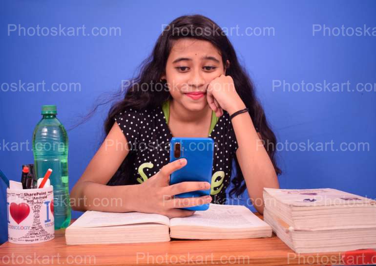 A Young Girl Busy With Mobile Phone Stock Image