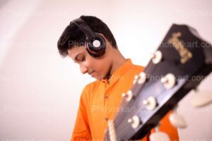 an-indian-boy-with-orange-kurta-playing-guiter