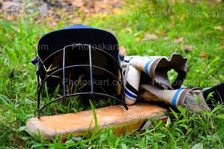 High Quality Image Of Cricket Bat Gloves And Helmet In A Field