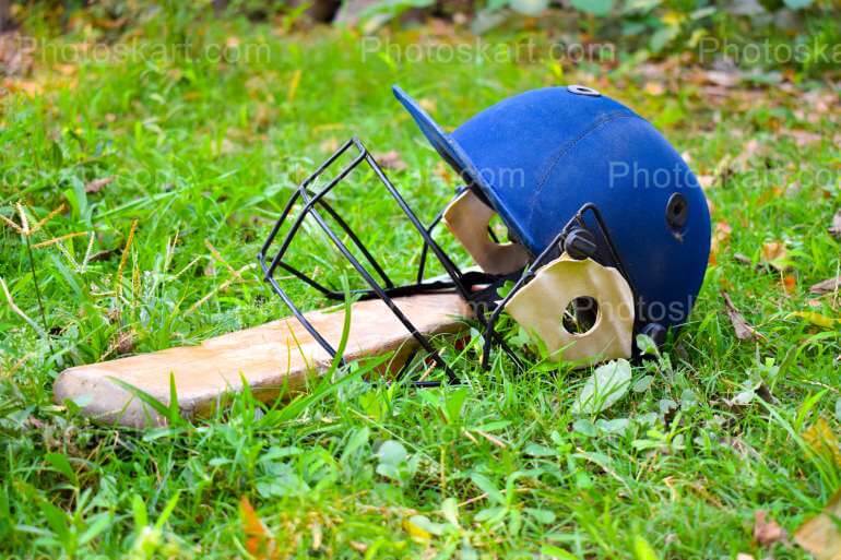 Cricket Helmet And Bat In A Field Stock Image