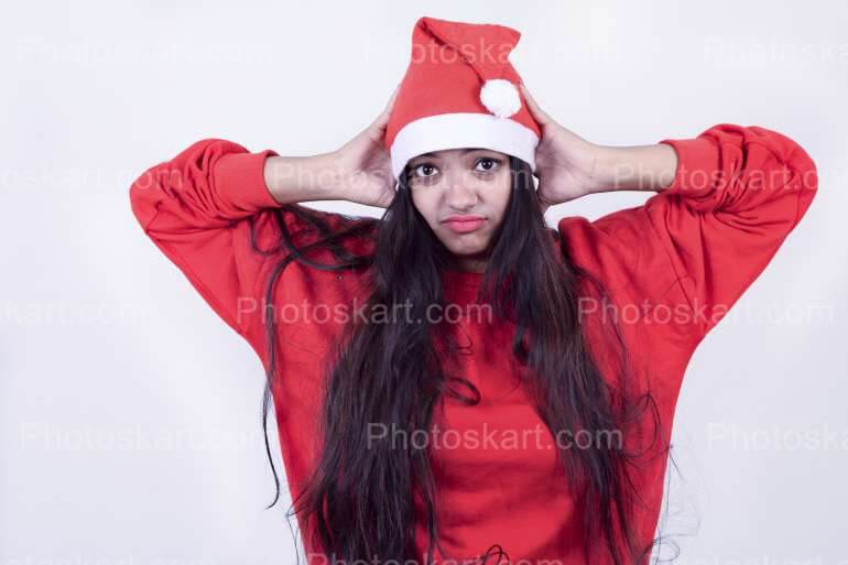 A Girl With Irritated Expression While Wearing Santa Cap