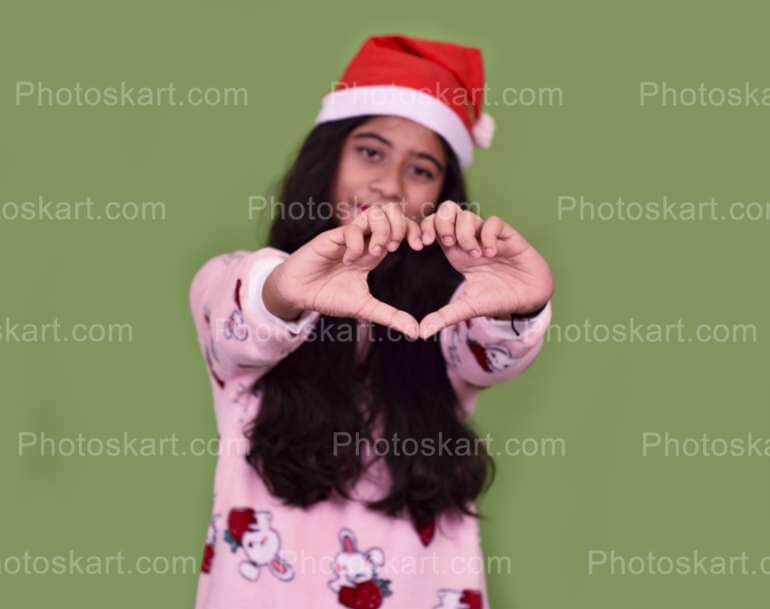 Smart Girl Posing Heart Gesture While Wearing Red Santa Hat