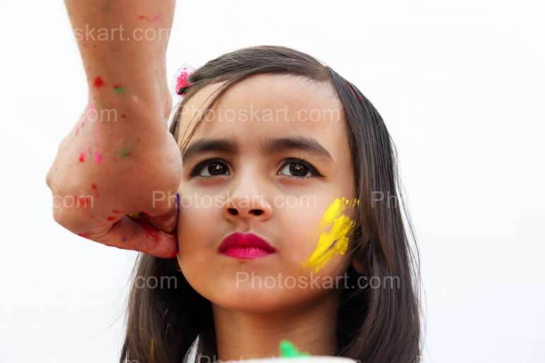 Indian Girl Getting Color On Her Face In Holi Festival