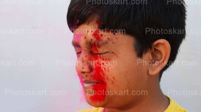 Red Color Splash On Face Of Indian Boy