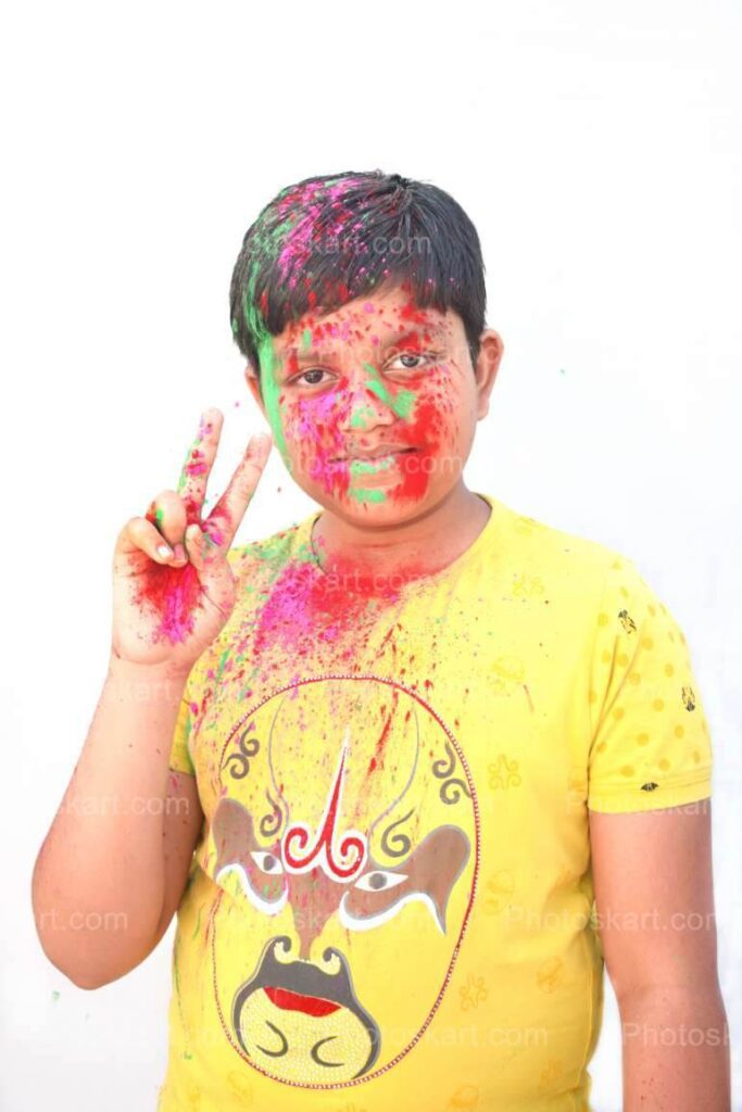 Smart Indian Boy Showing Two Fingers In Holi
