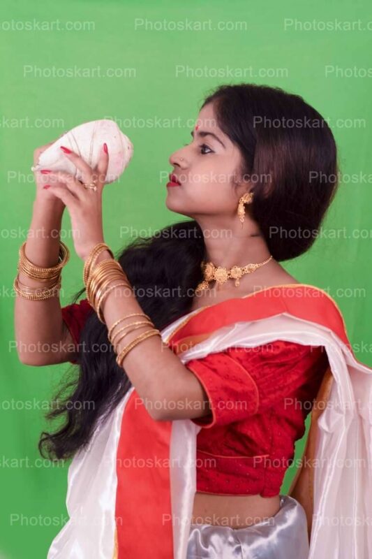 DG23623650922, beautifull hindu girl blowing conch shell hd royalty image, stock photos, hindu stock photos, traditional stock photos, bengali woman stock photos, agomoni photoshoot, puja photoshoot, girl, indian girl, indian cute girl, ma, culture, south asian culture, bengal, clay, clay idol, celebration, puja, festival, indian girl images, bengali festival, celebration, asia, bengali, festival costume, devi, beauty, face, clothing, ceremony, bridal, jewellery, durga model, festival season, durga puja look. girl with sari, sari, tradition, bengali tradition, god, durga puja look photo shoot with white and red saree, bengali saree, female, glamor, ethnicity, women, model, culture model, durga puja model, durga puja model hd image, puja model pose, festival model photoshoot, festival model images, lady, indian girl photoshoot, green background photoshoot, gorgeous, hindu girl, hindu girl photoshoot, stock, royaly, new